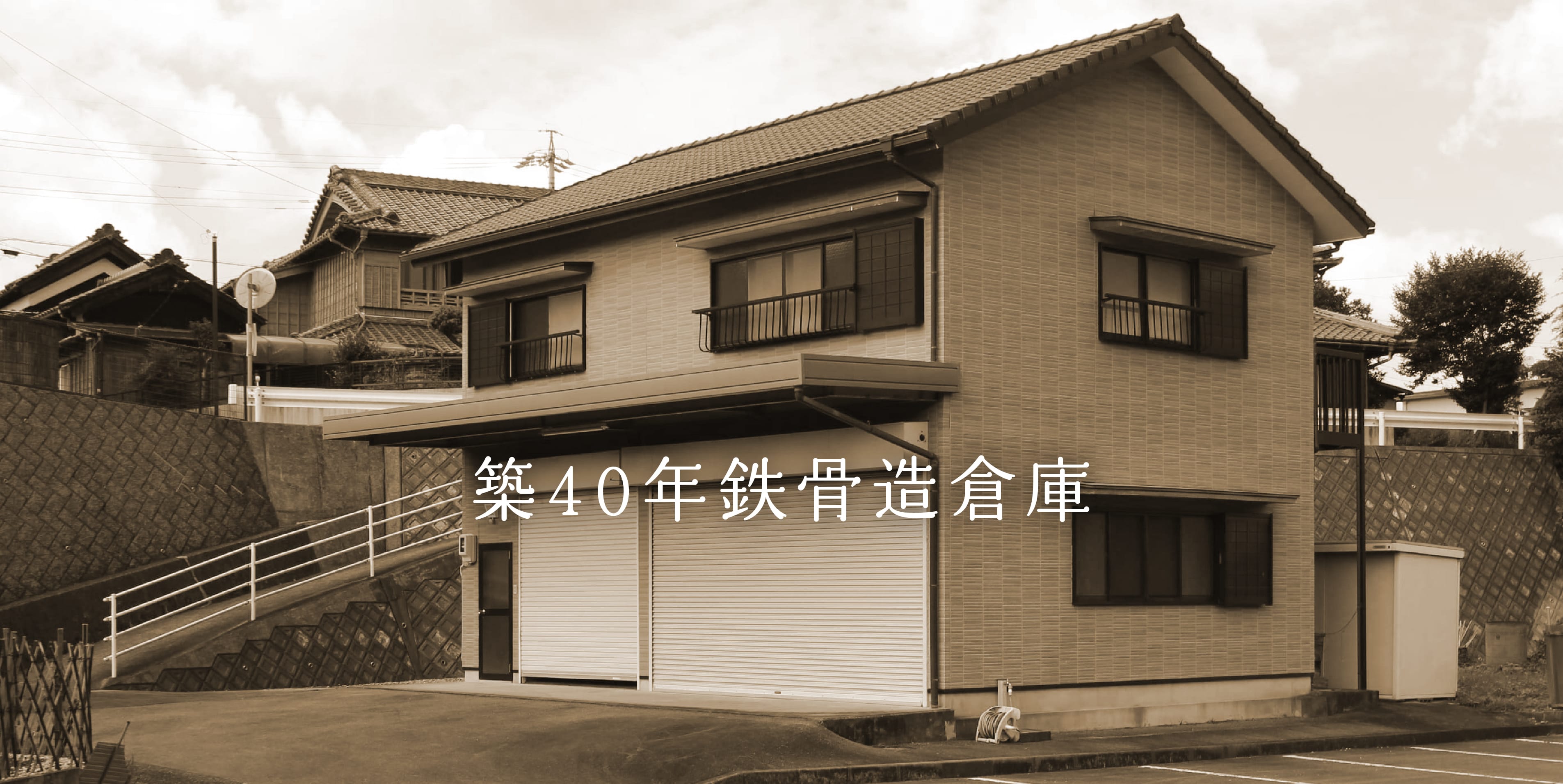 シャッターが閉じられ使われていない二階建ての倉庫の外観写真